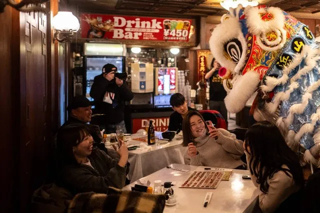 Diners watch a lion dance in a restaurant of the Chinatown area of Yokohama on February 10, 2024, on the first day of the Lunar New Year of the Dragon. (Photo by Philip Fong/AFP Photo)