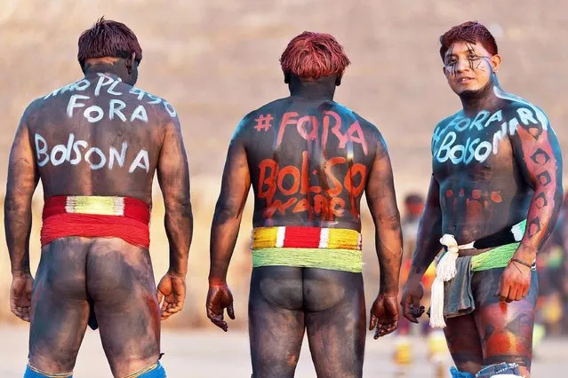 Yawalapiti men take part in a protest against Brazilian President Jair Bolsonaro during the Kuarup funeral ritual to honor the memory of Cacique Aritana, at Xingu Indigenous Park in Brazil on September 12, 2021. (Photo by Ueslei Marcelino/Reuters)