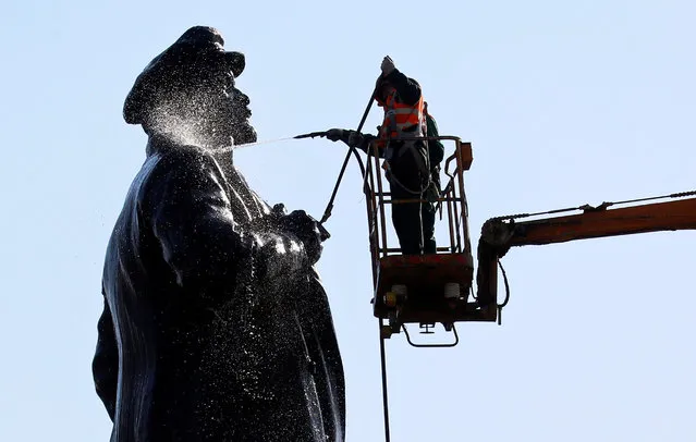 Employees of a public utility wash a monument to Soviet state founder Vladimir Lenin in Krasnoyarsk, Russia on April 25, 2019. (Photo by Ilya Naymushin/Reuters)
