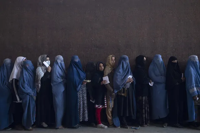 Women  queue to receive cash at a money distribution organized by the World Food Program in Kabul, Afghanistan, on Saturday, November 20, 2021. Thousands of Afghan families are registering for WFP aid  because they cannot afford food in the country’s economic collapse. (Photo by Petros Giannakouris/AP Photo)