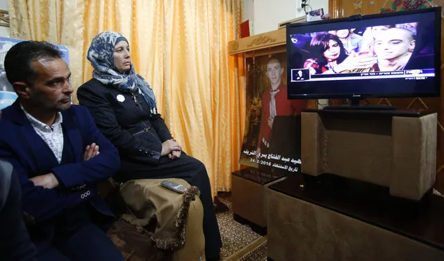 The father and mother of Palestinian Abdul Fatah al- Sharif, who was shot dead as he lay on the ground by Israeli soldier Elor Azaria in March 2016, watch on television the verdict of the trial of the soldier, at their family home in the occupied West Bank city of Hebron, on February 21, 2017. Israeli Judge Maya Heller handed down the sentence a month after Elor Azaria, 21, was found guilty of manslaughter for killing Palestinian Abdul Fatah al- Sharif as he lay on the ground in the southern occupied West Bank. (Photo by Hazem Bader/AFP Photo)