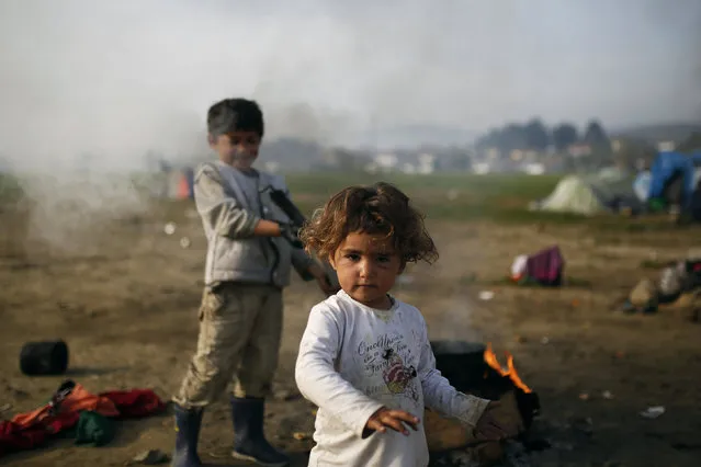 Children play by the fire at a makeshift camp for migrants and refugees at the Greek-Macedonian border near the village of Idomeni, Greece, April 1, 2016. (Photo by Marko Djurica/Reuters)