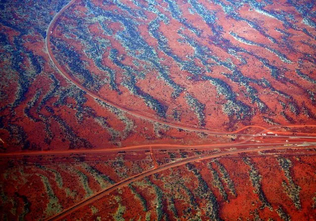 Roads go off in various directions next to sand dunes covered in vegetation in the Pilbara region of Western Australia December 2, 2013. (Photo by David Gray/Reuters)