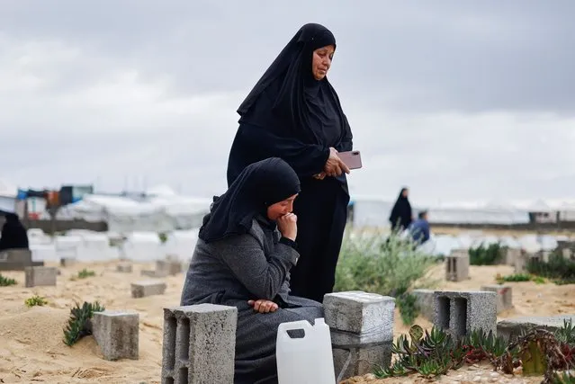 Palestinian women visit graves of people who were killed in the ongoing conflict between Israel and Palestinian Islamist group Hamas, on the day of Eid al-Fitr, in Rafah, in the southern Gaza Strip on April 10, 2024. (Photo by Mohammed Salem/Reuters)