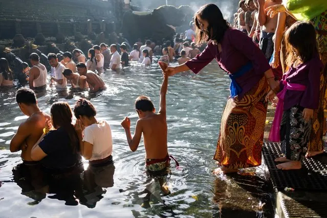 Balinese Hindu devotees bath in the holy springs at the water temple of Tirta Empul during a purification ritual called “Melukat” in Gianyar, Bali, Indonesia, 24 March 2024. Melukat is a traditional Balinese Hindu purification ritual performed to cleanse the body, mind, and soul from negative influences and impurities. It involves bathing in holy water at a sacred site, such as a natural spring or temple, while reciting prayers. The ritual is believed to restore balance and bring blessings for health, prosperity, and spiritual well-being. Melukat is often performed during significant life events or to address specific issues like illness or spiritual unrest. (Photo by Made Nagi/EPA/EFE)