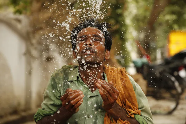 An Indian worker splashes water on his face to cool himself on a hot summer afternoon in Prayagraj, Uttar Pradesh, India, Thursday, June 13, 2019. Severe heat wave conditions are sweeping north and western parts of India with maximum temperature soaring to 48 degree Celsius (118 F) in some areas. (Photo by Rajesh Kumar Singh/AP Photo)