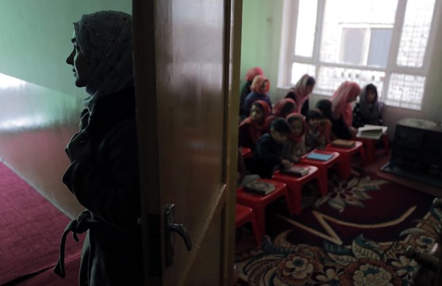Zahria Erian (L) takes a moment outside the room where she gives lessons at her home for a mixed group of Afghan children, at her home in Kabul, Afghanistan, 18 December 2021. Zahria Erian offers tution services at her home for Afghan children who are on three-month winter holidays and Afghan girls who are not able to attend secondary school due to Taliban restrictions. Since the Taliban announced three months ago that girls could not return to school until further notice, these teachers have taken it upon themselves to teach girl students in order to help those girls whose family cannot support them to join private classes or if their parents are also illiterate and aren't able to teach them. The new Islamist regime, which seized power on in August 2021, has kept nearly 1.1 million Afghan girls away from schools, while they are supposed to draft an action plan to allow girls to study within the limits of Sharia or Islamic law. (Photo by Maxim Shipenkov/EPA/EFE)