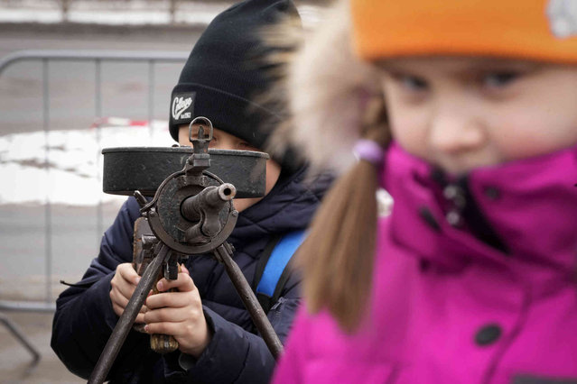 A boy aims a machine gun during a military-historical festival dedicated to the upcoming Victory Day in World War II in St. Petersburg, Russia, Saturday, April 20, 2024. (Photo by Dmitri Lovetsky/AP Photo)