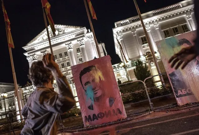 Protestors hit the pictures of Former Macedonian Prime Minister Nikola Gruevski (L) and Macedonian President George Ivanov (R) with balloons filled with paint in front of the government building, during the protest dubbed “colorful  revolution” against Macedonian President Ivanov's decision on wiretapping amnesty, in Skopje, The Former Yogoslav Republic of Macedonia, 27 April 2016. Ivanov on 12 April decided to abolish all judicial cases related to the big wire-tapping scandal that brought the country to early general elections scheduled for 05 June. (Photo by Georgi Licovski/EPA)