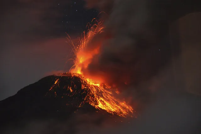 Ecuador's Tungurahua volcano spews molten rocks and large clouds of gas and ashes near Banos, south of Quito, April 9, 2014. According to local media, the volcano emitted a column of ash on the afternoon of April 4. Tungurahua, which means “Throat of Fire” in the local Quechua language, has been classified as active since 1999. (Photo by Carlos Campana/Reuters)