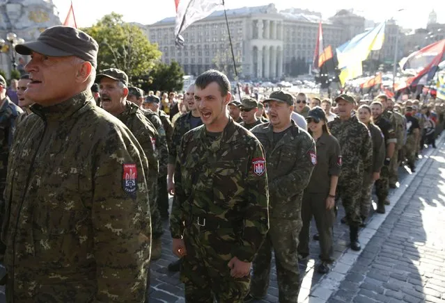 Members of the far-right radical group Right Sector, representatives of the Ukrainian volunteer corps and their supporters line up as they gather to march in central Kiev, Ukraine, July 3, 2015. The participants held a rally to demand from authorities to denounce the so-called Minsk peace agreements, to declare the military conflict in eastern Ukraine a war, to equip volunteer battalions by up-to-date standards and to break off diplomatic ties with Russia, according to local media. (Photo by Valentyn Ogirenko/Reuters)