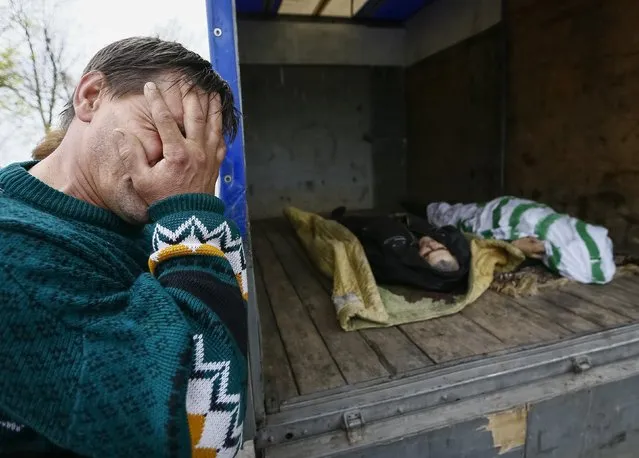 A local resident reacts after looking at the bodies of victims of a gunfight overnight near the city of Slaviansk, April 20, 2014. A fatal gun battle overnight near the eastern Ukrainian city of Slaviansk shows that the Ukrainian authorities are failing to rein in armed extremists, Russia's foreign ministry said on Sunday. (Photo by Gleb Garanich/Reuters)