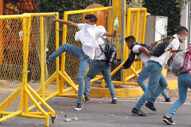 A student kicks a fence during a protest to demand the government to repeal a law that requires high school seniors to teach at least two people to read and write, as part of a graduation programme in Tegucigalpa, Honduras, May 4, 2016. (Photo by Jorge Cabrera/Reuters)