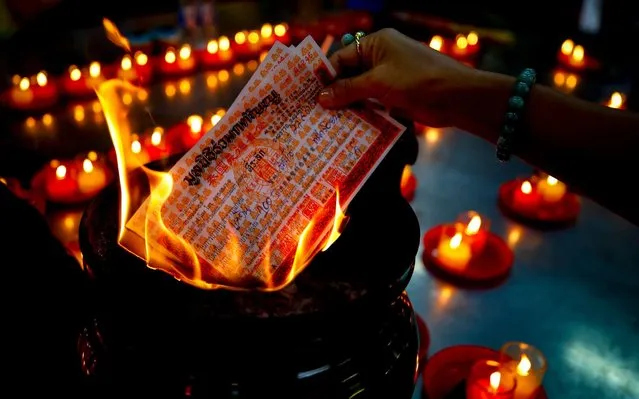 People burn coffin donation receipts in prayer at the Ruamkatanyu Foundation next to Wat Hua Lamphong temple in Bangkok, Thailand, 27 August 2019. Adjacent to the popular Royal Buddhist temple Wat Hua Lamphong is the Ruamkatanyu Foundation where devotees earn merits by sponsoring coffins. The Ruamkatanyu Foundation collects donations for coffins, destined for those without relatives or unable to afford one. Usually hospitals contact the Ruamkatanyu Foundation to request the coffins. (Photo by Diego Azubel/EPA/EFE/Rex Features/Shutterstock)
