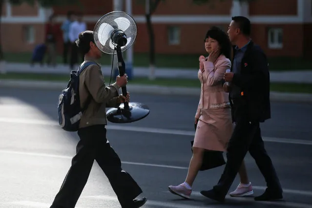 A man carries an electric fan at the newly built Mirae Scientists Street in central Pyongyang, North Korea May 7, 2016. (Photo by Damir Sagolj/Reuters)