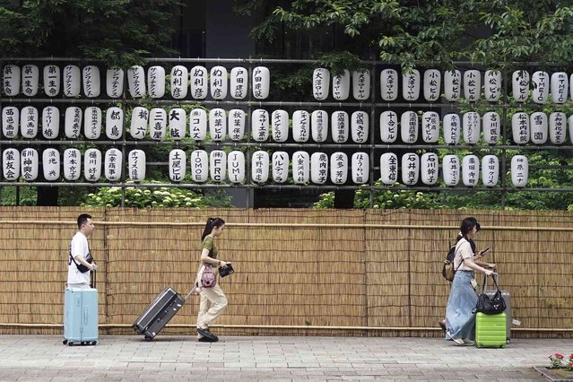 Tourists walk near festive lanterns Monday, May 27, 2024, in Tokyo. The names of the festival sponsors are written on the lanterns. (Photo by Eugene Hoshiko/AP Photo)
