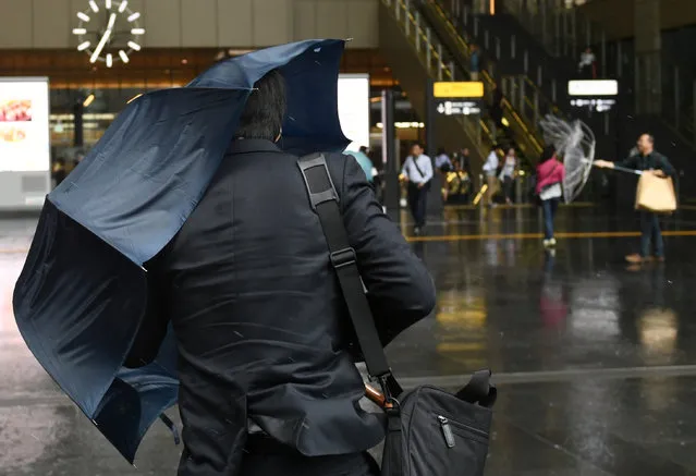 A man walks in the rain close to Osaka Station as Typhoon Hagibis approaches Osaka, Japan, October 12, 2019. (Photo by Annegret Hilse/Reuters)