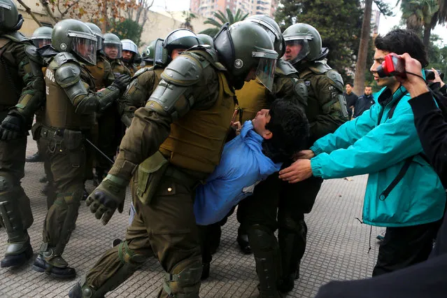 A demonstrator is detained during an unauthorized march called by secondary students to protest against government education reforms in Santiago, Chile, May 26, 2016. (Photo by Ivan Alvarado/Reuters)