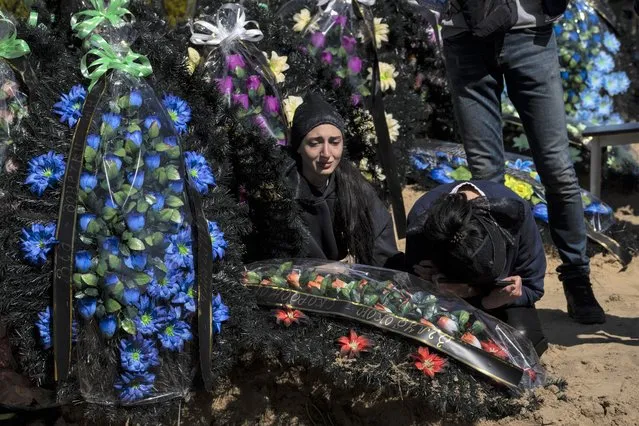 The sister and mother mourn the death of Anatoliy Kolesnikov, 30, a territorial defense soldier who was killed by Russian, in Irpin, in the outskirts of Kyiv, Ukraine, Friday, April 15, 2022. (Photo by Rodrigo Abd/AP Photo)