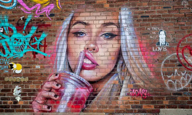 Street artist Irony’s mural of a young woman on Jamaica Street in Liverpool, UK on September 22, 2019. The city has recently been transformed with bold murals painted by local artists on walls and buildings. Recognisable faces including those of the Beatles, Jürgen Klopp and Stephen Hawking. (Photo by Peter Byrne/PA Wire Press Association)