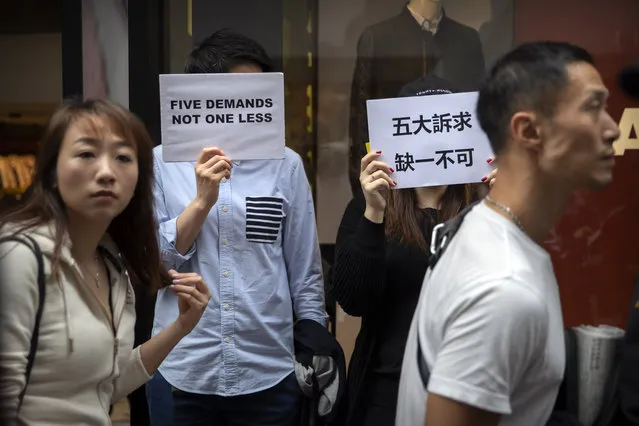 Protesters hold signs reading “Five Demands, Not One Less” during a rally in Hong Kong, Monday, December 16, 2019. (Photo by Mark Schiefelbein/AP Photo)