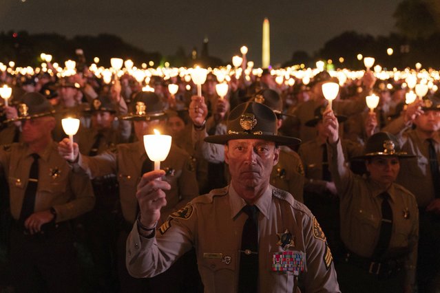 Law enforcement personnel hold candles during the 35th Annual Candlelight Vigil to honor the law enforcement officers who lost their lives in 2022, during the National Police Week at the National Mall in Washington, late Saturday, May 13, 2023. (Photo by Jose Luis Magana/AP Photo)