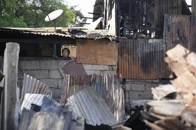 A man looks at the damage left from a fire that gutted houses in Quezon city, Philippines on Monday, May 2, 2022. Investigators said the fire killed several people and left more than a hundred people homeless. (Photo by Aaron Favila/AP Photo)
