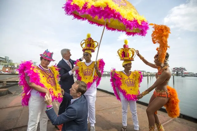 The Netherlands' Minister of Kingdom Relations Ronald Plasterk (2nd L, top) and Amsterdam Gay Pride founder Siep de Haan help adjust costumes of participants from Curacao before their boat leaves for the festival's canal parade in Amsterdam, the Netherlands August 1, 2015. The boat took part in the 20th Canal Gay Parade to protest against the illegal status of gay marriage in Aruba, Curacao and Sint Maarten, three Caribbean members of the Kingdom of the Netherlands. (Photo by Cris Toala Olivares/Reuters)