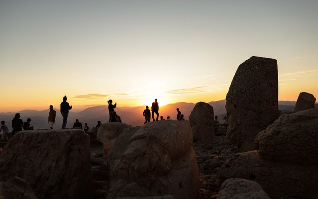 People take pictures near the large statues at the tomb-sanctuary of King Antiochus on top of Mount Nemrut during sunset at the Kahta discrict of Adiyaman, Turkey, 11 August 2024. Mount Nemrut is a mountain in southeastern Turkey measuring around 2,134 meters (7,000 feet) high. At the summit, lies several statues suspected to be the guardians of a royal tomb dating back to the 1st century BC. (Photo by Erdem Şahin/EPA/EFE)