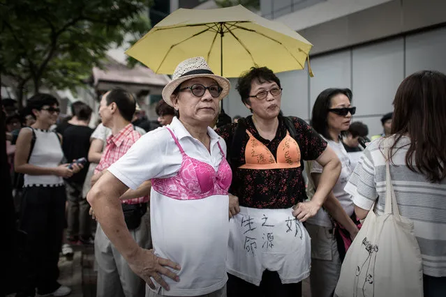 Protesters wear bras during a demonstration outside the police headquarters in Hong Kong on August 2, 2015. The demonstrators gathered in support of a Hong Kong woman who was sentenced to three-and-a-half months jail for using her breast to bump a police officer during a protest. (Photo by Philippe Lopez/AFP Photo)
