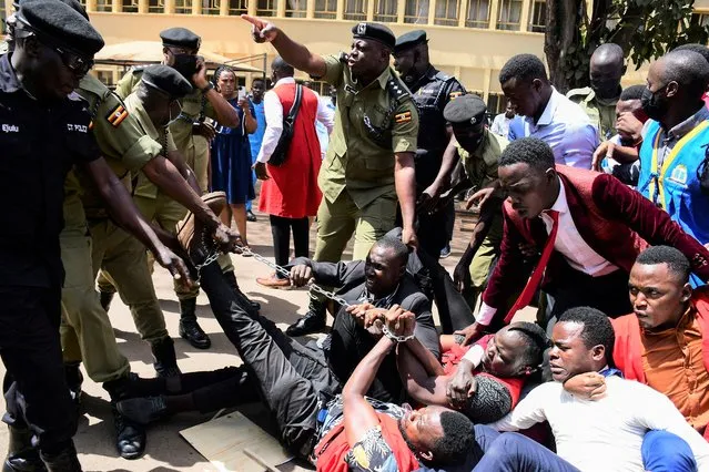 Ugandan police officers detain students marching towards parliament to protest against steep rise in the cost of commodities, in Kampala, Uganda on May 5, 2022. (Photo by Abubaker Lubowa/Reuters)