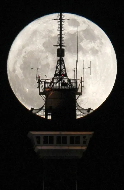 The moon is seen behind the top of the radio and television tower “Funkturm” in Berlin March 19, 2011. Saturday will see the rise of a full moon called a “Super Moon” when it arrives at its closest point to the Earth in 2011, a distance of 221,565 miles or 356,575 km away