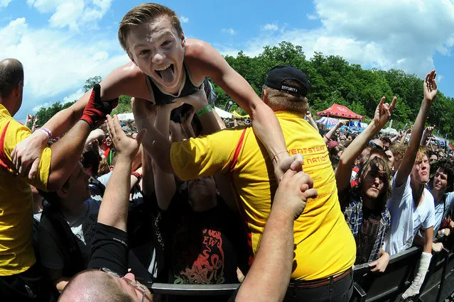 An excited fan is carried away by security personnel after crowd surfing to the music of the band Four Year Strong during the Vans Warped Tour at the Toyota Pavilion at Montage Mountain in Scranton, on Jule 9, 2014. (Photo by Butch Comegys/The Scranton Times-Tribune/Associated Press)