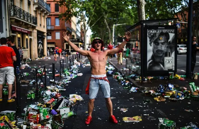 A Wales supporter cheers on a street dirty with rubbish left by Wales supporters before the Euro 2016 group B football match between Russia and Wales at the Stadium Municipal in Toulouse on June 20, 2016. (Photo by Bulent Kilic/AFP Photo)