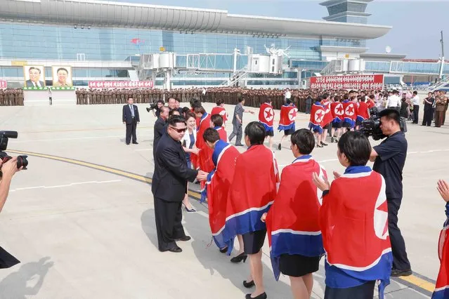 North Korean leader Kim Jong Un and his wife Ri Sol Ju greet North Korea's female soccer team as they arrive at Pyongyang International Airport on Monday after winning the 2015 EAFF East Asian Cup, in this undated photo released by North Korea's Korean Central News Agency (KCNA) in Pyongyang on August 10, 2015. (Photo by Reuters/KCNA)