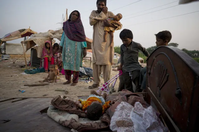 Members of a Pakistani nomad family stand outside their makeshift home in Islamabad, Pakistan, Wednesday, August 5, 2015. (Photo by B. K. Bangash/AP Photo)