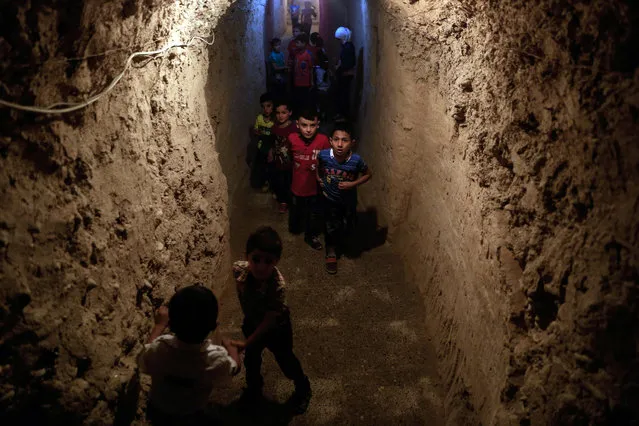 Syrian children play in an underground playground built to protect them from shelling in the rebel-held town of Erbin, east of the capital Damascus, on July 7, 2016 during Eid al-Fitr, which marks the end the Muslim holy month of Ramadan. More than 280,000 people have been killed and millions have been displaces since Syria’s conflict broke out in March 2011. (Photo by Sameer Al-Doumy/AFP Photo)