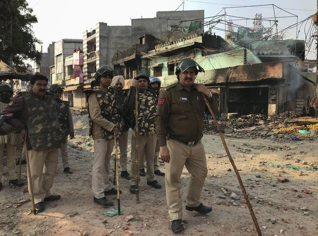 Indian policemen guard an area vandalized following violence between two groups in New Delhi, India, Tuesday, February 25, 2020. At least seven people, including a police officer, were killed and dozens injured in the clashes, police said Tuesday. (Photo by Rishabh. R. Jain/AP Photo)
