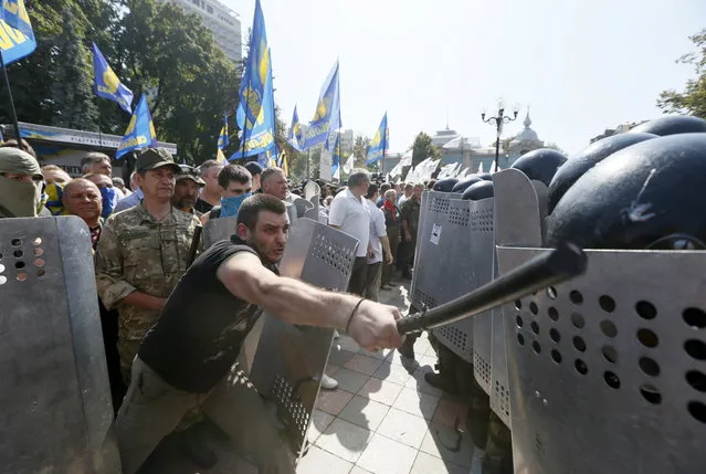 Demonstrators, who are against a constitutional amendment on decentralization, clash with police outside the parliament building in Kiev, Ukraine, August 31, 2015. Ukraine's national guard said about 50 of its members were hurt, including four with serious wounds, by the blast. (Photo by Valentyn Ogirenko/Reuters)