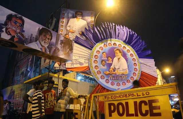 Fans of Indian actor Rajinikanth wait next to police barricades outside a theatre to buy tickets on the eve of release of his new movie “Kabali” in Chennai, India, Thursday, July 21, 2016. (Photo by Aijaz Rahi/AP Photo)