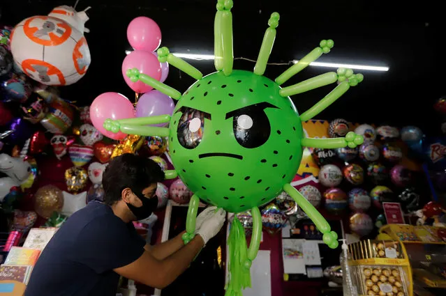 Victor Vazquez works on a balloon depicting the coronavirus at a store, as the spread of the coronavirus disease (COVID-19) continues, in Cuautlancingo, in Puebla state, Mexico on April 21, 2020. (Photo by Imelda Medina/Reuters)