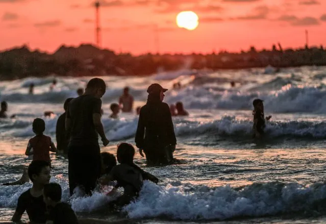 Palestinians enjoy the beach waters during a hot weather day in Gaza City on August 27, 2022. (Photo by Mahmoud Issa/SOPA Images/LightRocket via Getty Images)