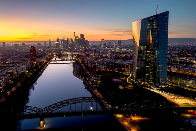The sun has set behind the European Central Bank, right, and the buildings of the banking district in Frankfurt, Germany, Thursday, December 26, 2024. (Photo by Michael Probst/AP Photo)