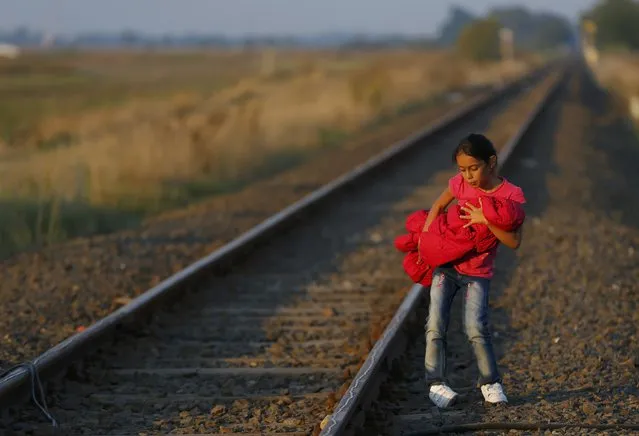 A migrant child holds a baby as she arrives at a collection point near the Serbian-Hungarian border in Roszke, Hungary September 13, 2015. (Photo by Laszlo Balogh/Reuters)