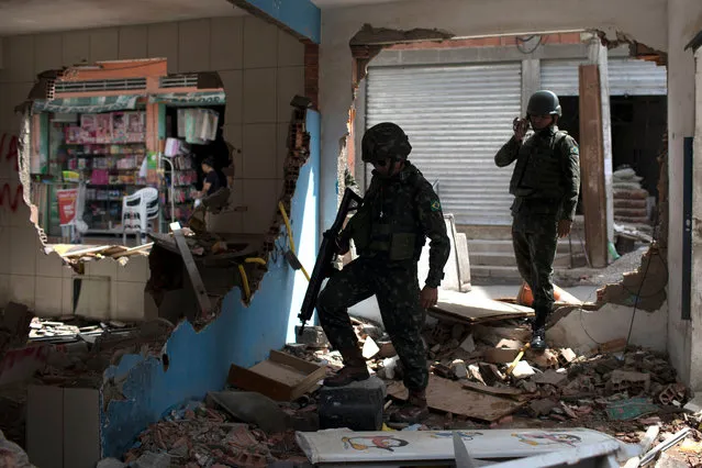Brazilian army soldiers check damages at a destroyed police post during a security operation, at Barbante favela in Rio de Janeiro, Brazil on November 30, 2017. (Photo by Leo Correa/AFP Photo)