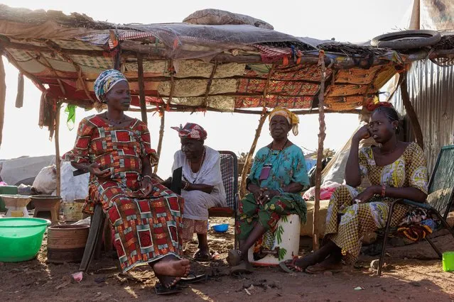 Internally displaced people (IDP) sit outside a makeshift shelter at the Faladie IDP camp in Bamako on November 9, 2022. People fleeing a decade-long conflict in Mali take refuge at the Faladie IDP camp. (Photo by Ousmane Makaveli/AFP Photo)