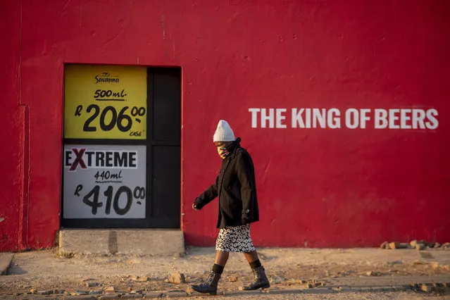 A woman walks in front of a closed alcohol shop in the township of Soweto outside of Johannesburg, South Africa, Monday, July 13, 2020, The sale of alcohol been banned since the country went into a strict lockdown to fight the spread of the new coronavirus. (Photo by Themba Hadebe/AP Photo)