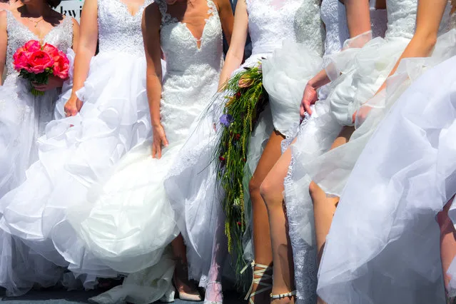 Wedding group of brides posing with a naked leg. (Photo by Alex Luminous/Rex Features/Shutterstock)