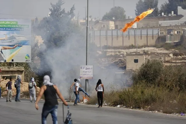 Palestinian protesters throw a molotov cocktail towards Israeli troops during clashes near the Jewish settlement of Bet El, near the occupied West Bank city of Ramallah October 5, 2015. (Photo by Mohamad Torokman/Reuters)