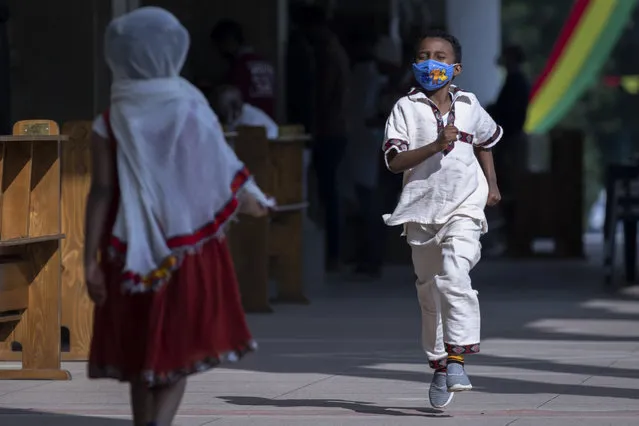 A young boy wearing a face mask to curb the spread of the coronavirus runs at a prayer ceremony to mark the holiday of “Enkutatash”, the first day of the new year in the Ethiopian calendar, which is traditionally associated with the return of the Queen of Sheba to Ethiopia some 3,000 years ago, at Bole Medhane Alem Ethiopian Orthodox Cathedral in the capital Addis Ababa, Ethiopia Friday, September 11, 2020. (Photo by Mulugeta Ayene/AP Photo)